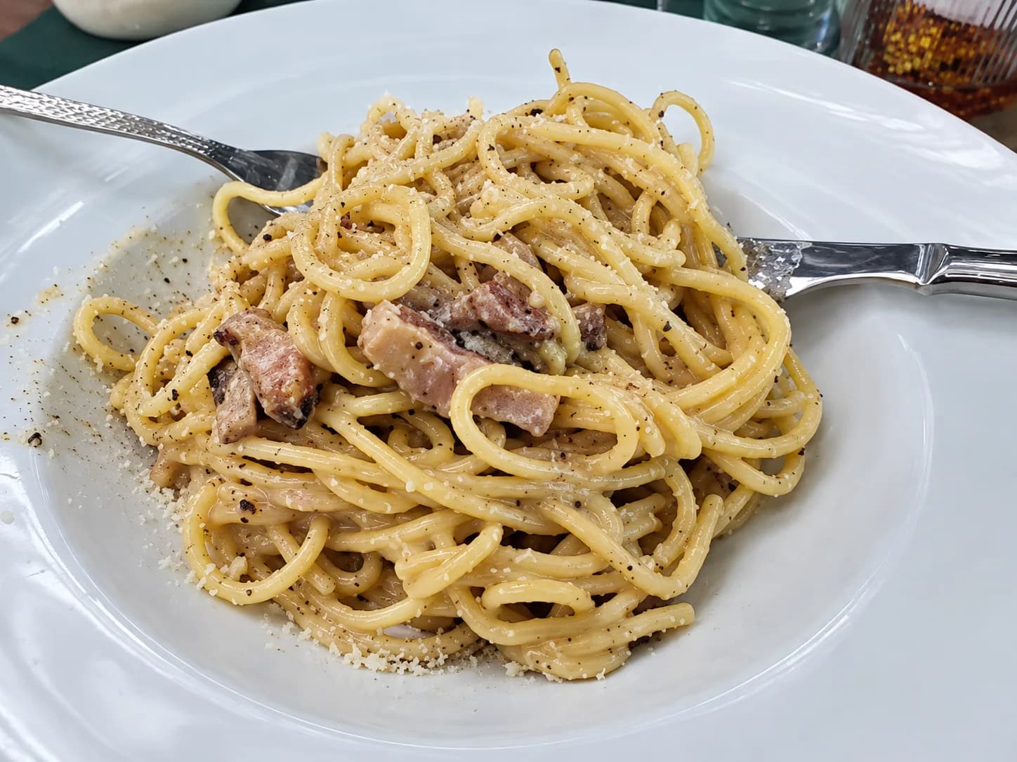 Pappardelle mezclándose dentro de la rueda de Parmigiano, junto a la mesa